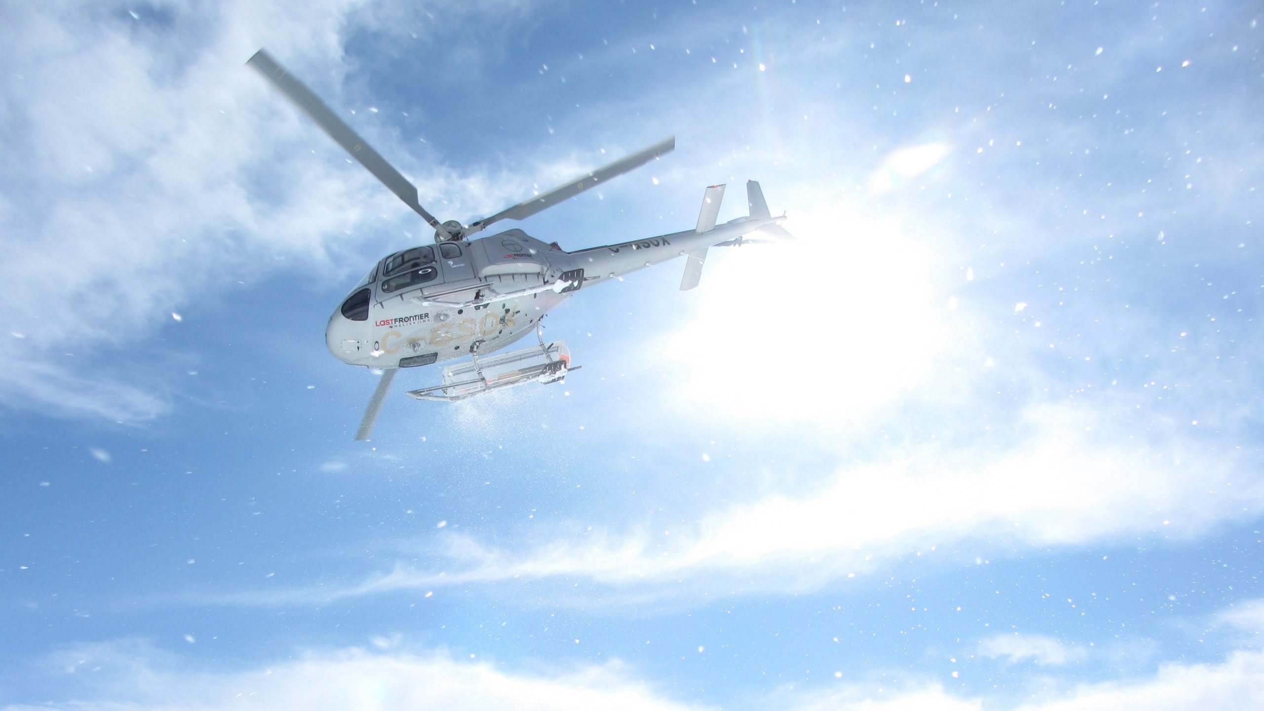 Photo of a helicopter flying in Alaska in blue sky background