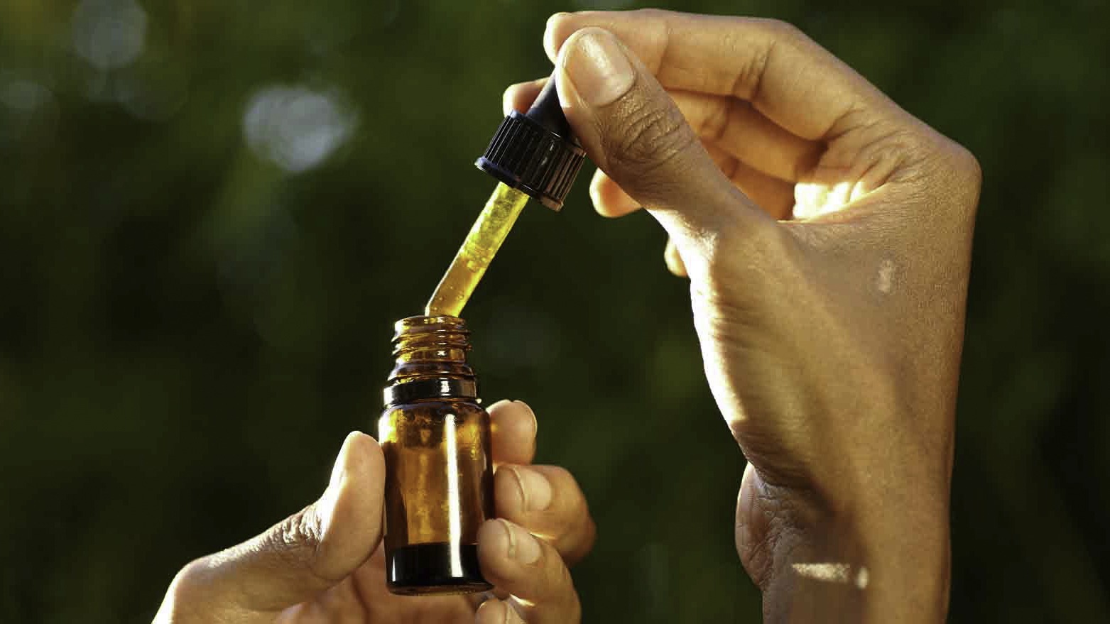 person holding a cbd bottle and dropper in texas