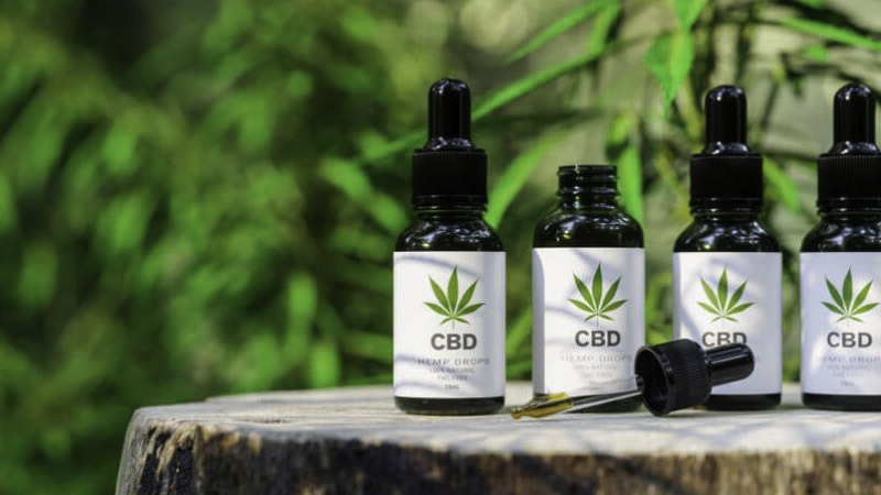 cbd oil bottles next to each other on a wooden tree