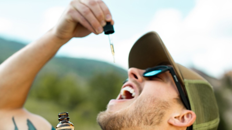 a guy taking cbd oil under his tongue