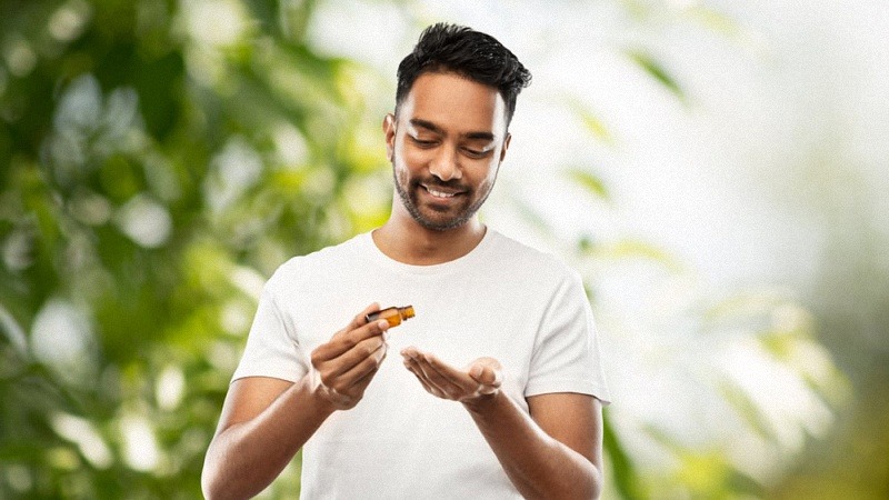 Man Holding CBD Oil Bottle Smiling