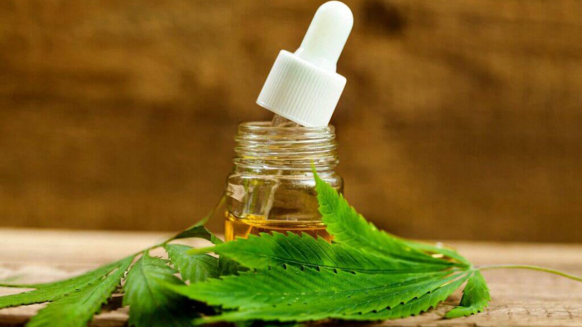 CBD Oil with Hemp Leaves Brown Background
