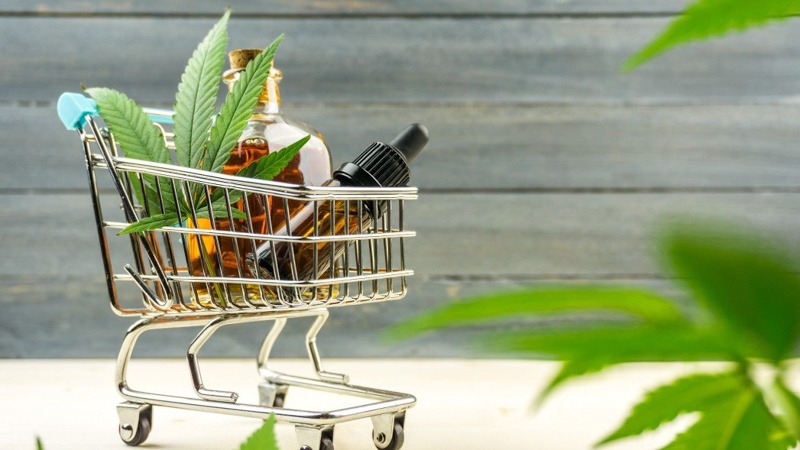 CBD Oil with Hemp Leaf in the cart on a grayish background