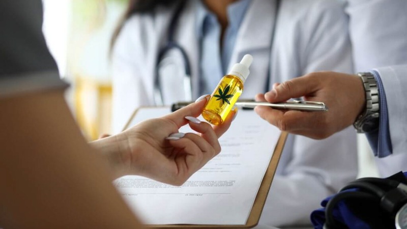 a person holding CBD oil with doctor