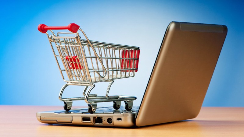 cart miniature on top of a laptop in white blue background