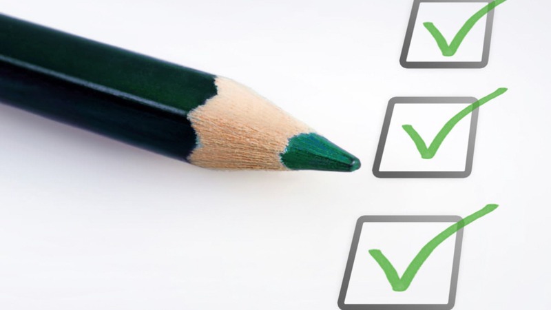 Checklist with Green Pencil on a White Paper